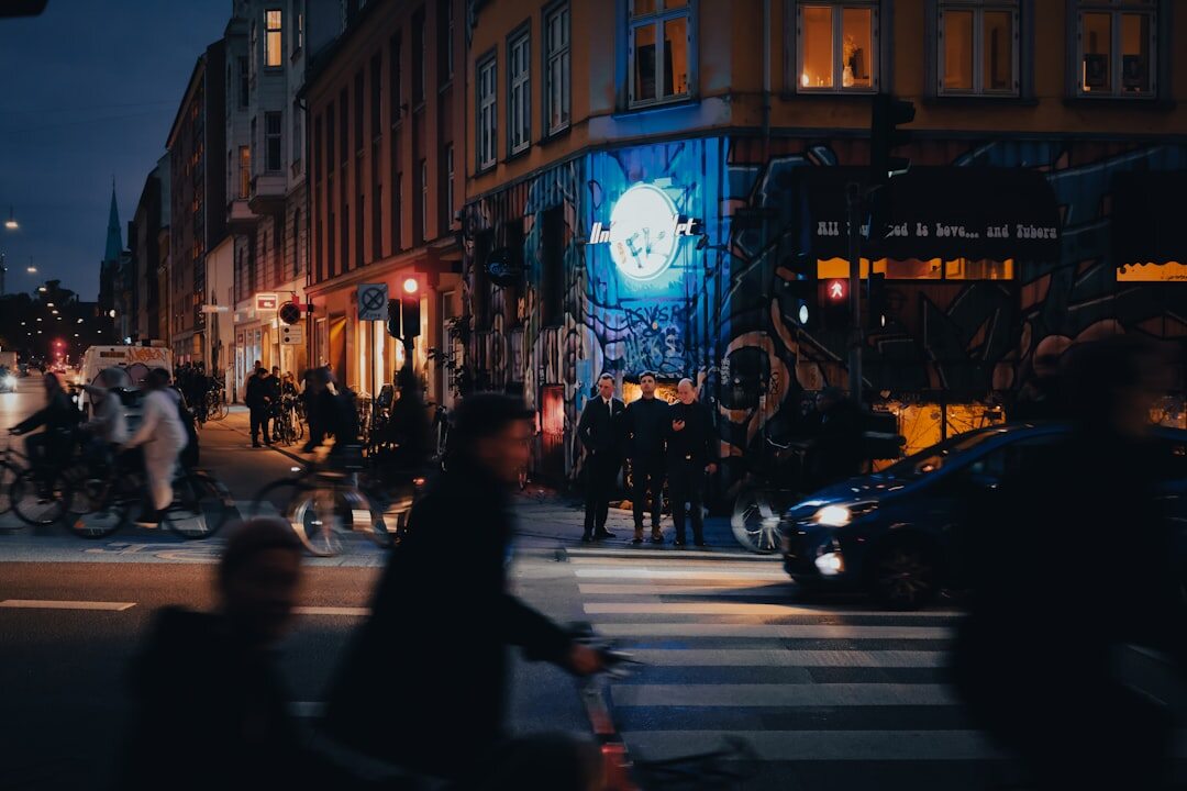 Cyclists crossing a cobbled street in central Copenhagen at dusk